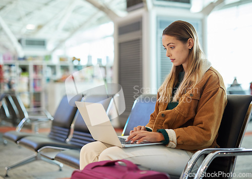 Image of Airport, travel and woman typing on laptop in lobby, social media or internet browsing. Immigration, freelancer and female with computer for networking, web scrolling and waiting for flight departure