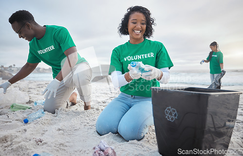 Image of Volunteer group, beach clean and recycling plastic bottle for community service, pollution and earth day. Black woman and man ngo team cleaning sand for climate change, nature and helping environment