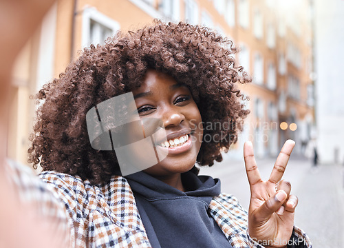 Image of Selfie, peace sign and black woman portrait with a smile from travel in a urban city. Happy, young person and face of a African female on a holiday with freedom by a building with blurred background