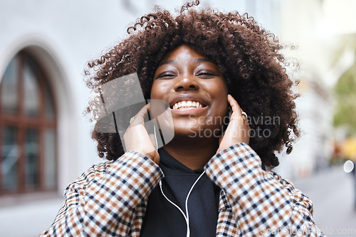 Image of Freedom, city and black woman listening to music, radio or song in the street while walking to work. Happy, smile and African female streaming playlist, album or audio with earphones in road in town.