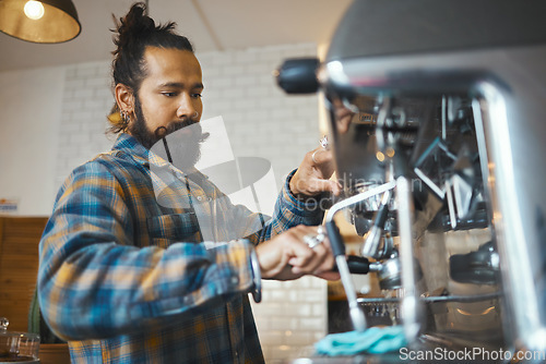 Image of Man in coffee shop, barista working machine and create drink with focus and small business, workflow and process. Espresso, latte or cappuccino production, busy server in cafe and professional