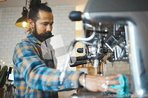 Image of Man in coffee shop, barista cleaning machine for drink with focus and small business, workflow and process. Clean up are espresso, latte or cappuccino production, cafe with hygiene and disinfection