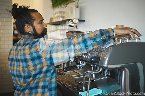 Image of Man in cafe, barista and machine for drink with focus and small business, workflow and process. Clean up are espresso, latte or cappuccino production, coffee shop with hygiene and disinfection