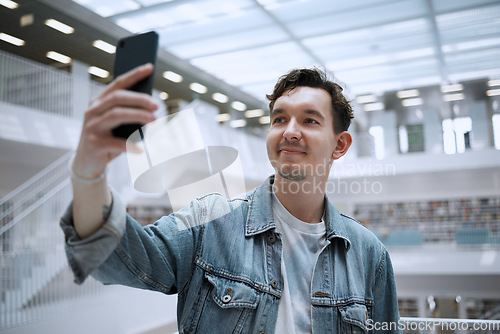 Image of Selfie, campus and man in library for research update, social media or blog post with live streaming his experience. Education, study and phd person in university with smile for profile picture