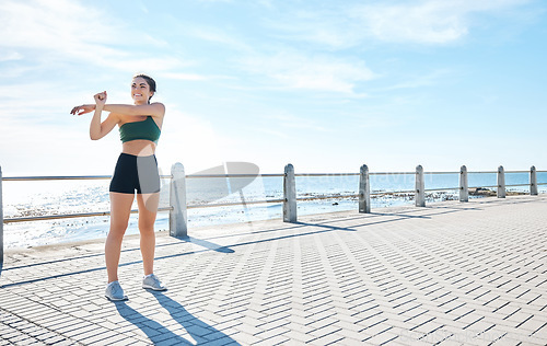 Image of Fitness, woman and stretching arms at the beach for running, exercise or cardio workout outdoors. Active female runner in warm up arm stretch preparation for run, exercising or training in nature