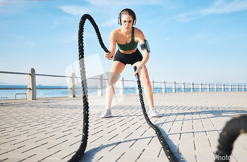 Image of Fitness, woman and battle rope at the beach for intense arm workout, training or endurance exercise. Active female with ropes in power workout, exercising or focus for muscle bodybuilding outdoors