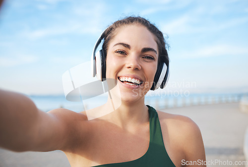 Image of Selfie, fitness and woman headphones for outdoor training, running or exercise on video call for influencer update. Music, portrait and profile picture of sports person at beach workout or cardio