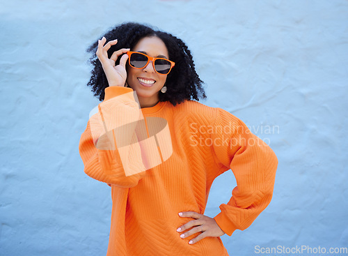 Image of Trendy portrait, sunglasses and black woman isolated on blue background gen z, youth or fashion clothes. Happy person or beauty model in confidence, vision style and orange color on brick wall mockup