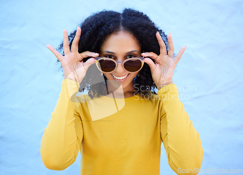 Image of Trendy sunglasses, portrait and black woman isolated on blue background gen z, youth and fashion clothes. Summer, person or beauty model smile with vision style, yellow color and brick wall mockup