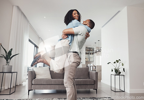 Image of Love, man pick up woman and in living room for happiness, loving and celebration for relationship. Portrait, couple or male hug female in lounge, joyful or achievement with smile, relax or cheerful