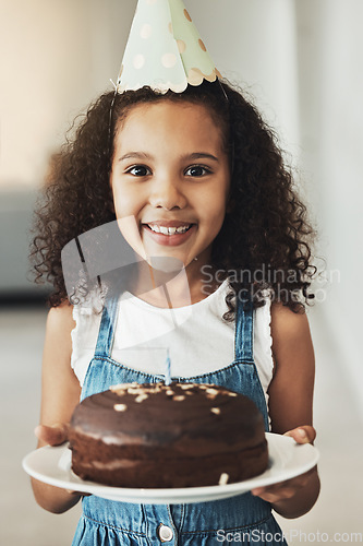 Image of Happy girl with birthday cake, portrait with child in home and surprise celebration in Atlanta house alone. Young African kid with smile in homemade chocolate dessert, hat on curly hair and excited