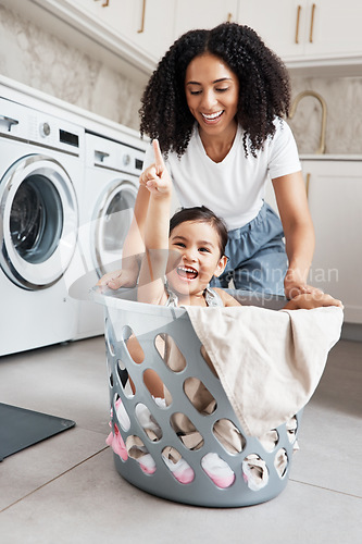 Image of Mom, laundry and girl kid in basket by washing machine for cleaning, bonding or comic time in house. Crazy fun, mother and daughter with happiness, love and playing in family home with smile on face