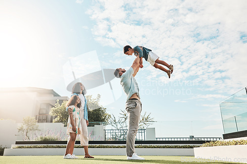 Image of Family, sky and real estate with a man lifting his son outdoor while bonding as a new homeowner group. Kids, love or summer with parents and children standing outside in the garden of a home property