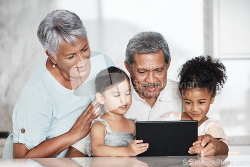 Image of Learning, grandparents and kids with tablet in home, playing online games or educational app. Bonding, touchscreen or care of happy family watching movie, film or video on digital technology in house