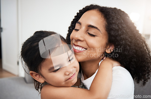 Image of Hug, love and girl with mother on a sofa, happy and smile while hugging in their home together. Family, embrace and parent with child on a couch, bond and cheerful, loving and caring in a living room