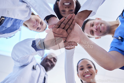 Image of Healthcare, teamwork and hands together in huddle for team building, collaboration and motivation at hospital. Doctors, happy faces of medical employees in solidarity and help or support from below.