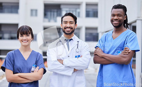 Image of Portrait, healthcare or collaboration with a doctor and team standing arms crossed outside of a hospital. Medical, teamwork or trust with a man and woman professional medicine group feeling confident