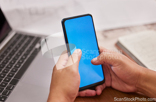 Image of Person, hands and phone with green screen on mockup by laptop for advertising, marketing or communication at office desk. Hand of employee on mobile smartphone display or chromakey for advertisement