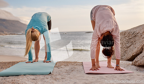 Image of Pilates, fitness and woman friends on the beach together for mental health, wellness or balance in summer. Exercise, diversity or nature with a female yogi and friend practicing yoga outside