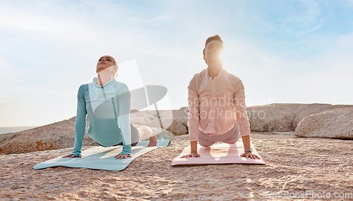 Image of Pilates, stretching and woman friends on the beach together for mental health, wellness or balance in summer. Exercise, diversity or nature with a yoga female and friend outside for inner peace