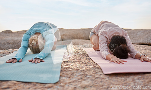 Image of Yoga, women or childs pose on beach mat in workout, training or bonding exercise for back pain. Relax, stretching or yogi friends in nature pilates, fitness flexibility or healthcare wellness on rock