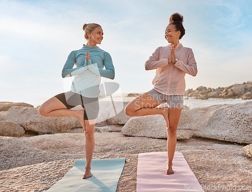 Image of Women friends, beach yoga and smile in morning with stretching legs for health, wellness and training. Black woman, exercise group and motivation for teamwork with balance, peace and support by sea