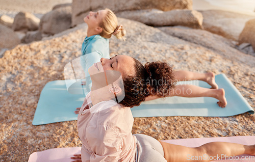 Image of Yoga, wellness and woman friends on the beach together for mental health or balance in summer from above. Exercise, diversity or nature with a female yogi and friend practicing meditation outside