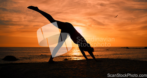 Image of Fitness, yoga and silhouette of woman at sunrise on beach for exercise, training and pilates workout. Morning, meditation and shadow of girl balance by ocean for sports, wellness and stretching legs