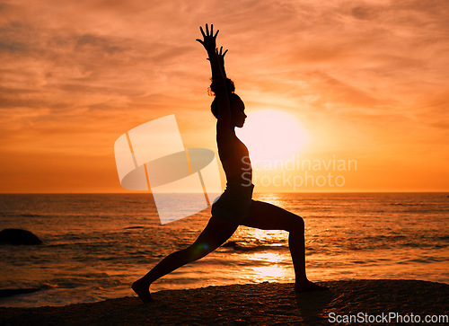Image of Fitness, yoga and silhouette of woman at sunrise on beach for exercise, training and pilates workout. Motivation, meditation and shadow of girl balance by ocean for sports, wellness and stretching