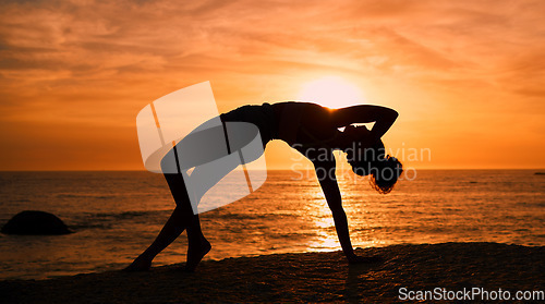 Image of Balance, yoga and silhouette of woman on beach at sunrise for exercise, training and pilates workout. Fitness, meditation and shadow of girl by ocean for sports, wellness and stretching in morning