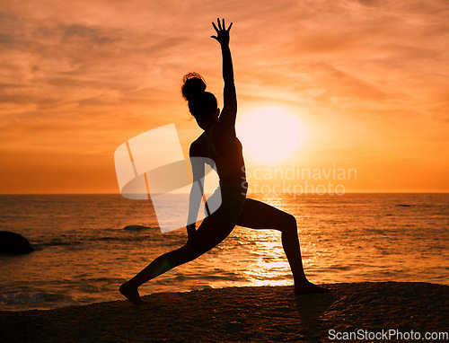 Image of Yoga, exercise and silhouette of woman on beach at sunrise for fitness, training and pilates workout. Motivation, meditation and shadow of girl balance by ocean for sports, wellness and stretching