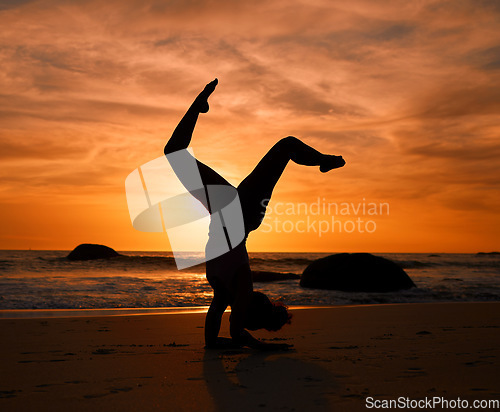 Image of Yoga, silhouette or handstand pose on sunset beach, ocean or sea in evening workout or relax exercise training. Yogi, woman or sand balance at sunrise for healthcare wellness fitness or strong body