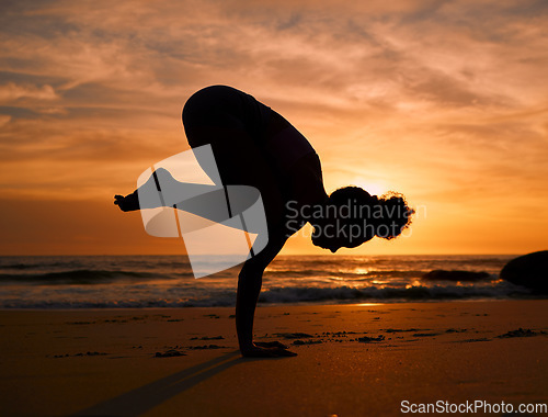 Image of Yoga, silhouette or crows pose on sunset beach, ocean or sea for evening exercise, workout or relax training. Yogi, woman or balance on sand at sunrise for fitness, healthcare wellness or strong body