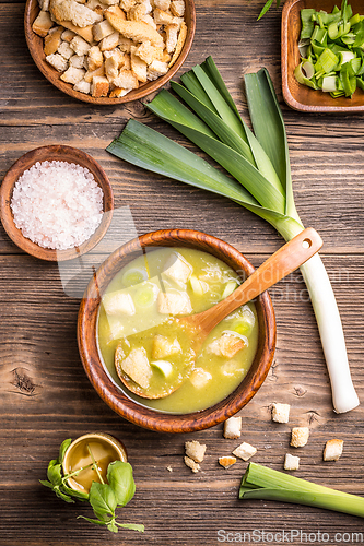 Image of Delicious leek soup in wooden bowl