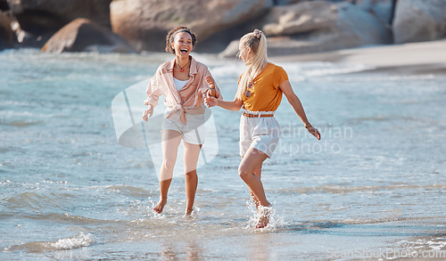 Image of Couple holding hands on beach, lesbian and happy in ocean, gay women outdoor with adventure and freedom to love. Interracial, laughter and holiday in Australia, lgbtq with travel and running in water