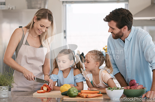 Image of Mom, dad and children cooking in kitchen with vegetables for nutrition, healthy lunch and vegan diet. Family, food and parents with girls learning, teaching and helping cut ingredients for meal prep