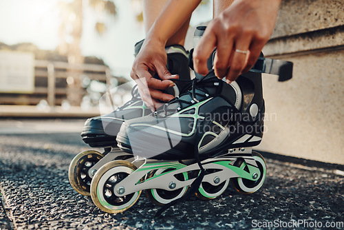 Image of Hands, fitness and tie roller skates in city to start workout, health and wellness exercise. Sports practice, training and black woman skater tying shoes in street to get ready for skating outdoors.