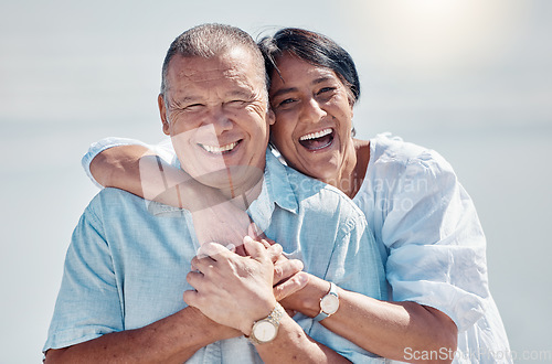 Image of Senior couple, portrait and hug at beach for laughing, love and relax on summer holiday, vacation or date. Happy retirement, man and woman embrace at sea for happiness, support and smile in sunshine