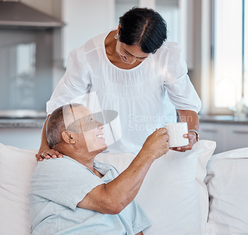 Image of Mature couple, bonding or giving coffee on sofa in house, home or relax living room in support, love or trust help. Smile, happy or retirement woman with morning tea cup for elderly man in marriage