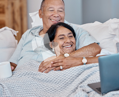 Image of Elderly couple streaming a movie on a laptop while relaxing on a sofa in their living room. Love, home and happy senior man and woman in retirement watching a video on computer together on a couch.