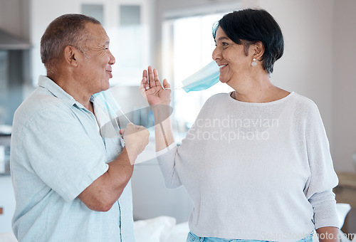 Image of Covid, remove home mask and senior couple together talking with a smile in a kitchen. Happy man, mature and marriage of a grandparents in house laughing with happiness after end of virus quarantine