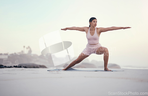 Image of Yoga, warrior pose and woman on the beach doing a meditation for zen in nature. Sea, sand and young person with mindfulness workout outdoor to calm and relax chakra energy with pilates by ocean