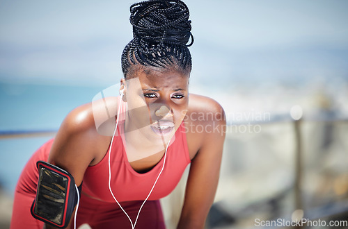 Image of Tired, running and black woman with runner fatigue by the ocean for workout, exercise and fitness. Summer, sweating and marathon run of a athlete on a sprinter break by the sea with rest from sport
