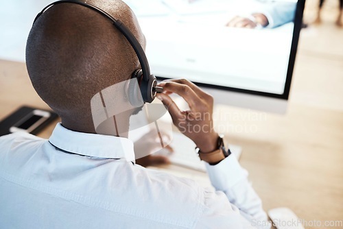 Image of Customer support, call center and back of a male consultant doing a consultation online in office. Contact us, career and African sales man or telemarketing agent working on crm strategy in workplace