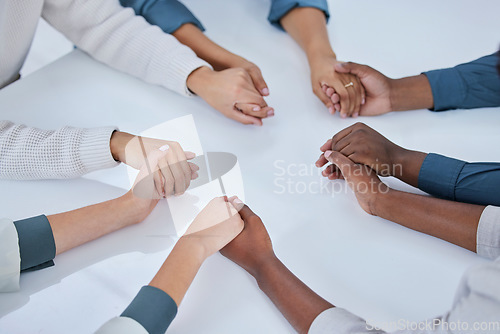 Image of Business people, holding hands and community in team building, trust or unity together above on table. Hand of group touching in collaboration for mission, support or agreement in solidarity at work