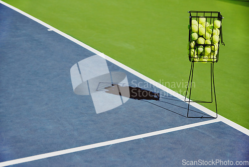 Image of Tennis, sport balls and basket of sports equipment on a training court outdoor with no people. Exercise, fitness and workout equipment shadow for match of game competition on turf ground in summer