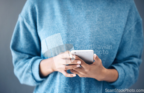 Image of Phone, hands and woman texting in studio for internet, search or social media on grey background. Online, communication and girl searching on smartphone, website or app while reading isolated closeup