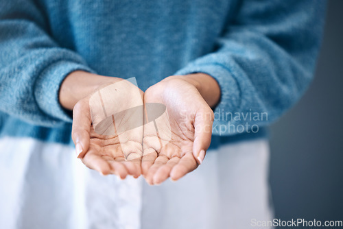Image of Hands open, charity and community with a woman begging for help in studio on a gray background. Support, poverty and palms with a female standing indoor to ask for aid, compassion or kindness