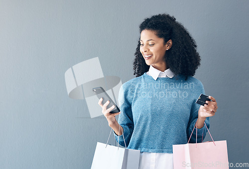 Image of Mockup, credit card and black woman with smartphone, shopping bags and ecommerce on grey studio background. African American female customer, lady and shopper with cellphone, boutique items or retail