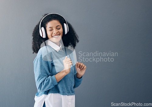 Image of Dance, music and black woman in studio with freedom, streaming or good mood on grey background. Radio, podcast and girl relax while dancing to audio, online and playlist on advertising isolated space